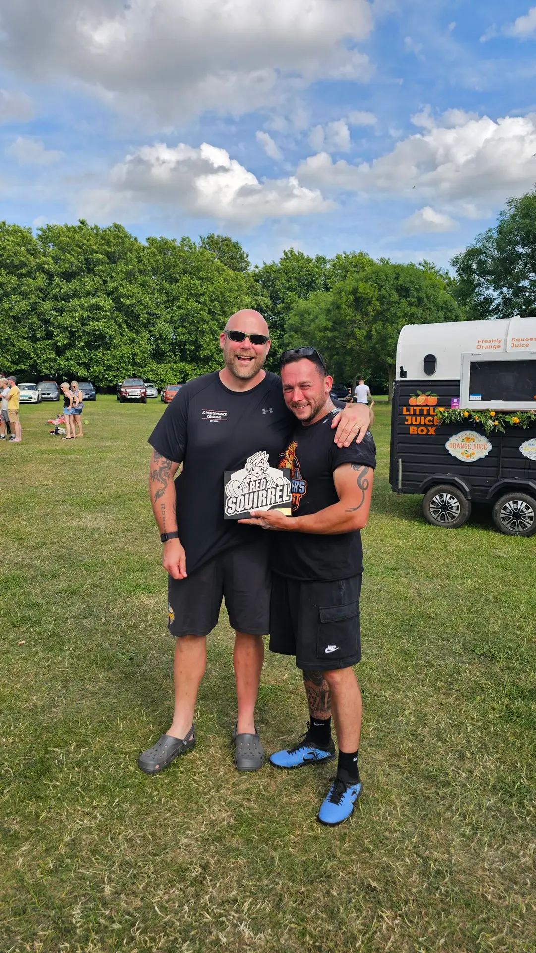 Male strength athlete posing with a competition trophy and JC Performance coach