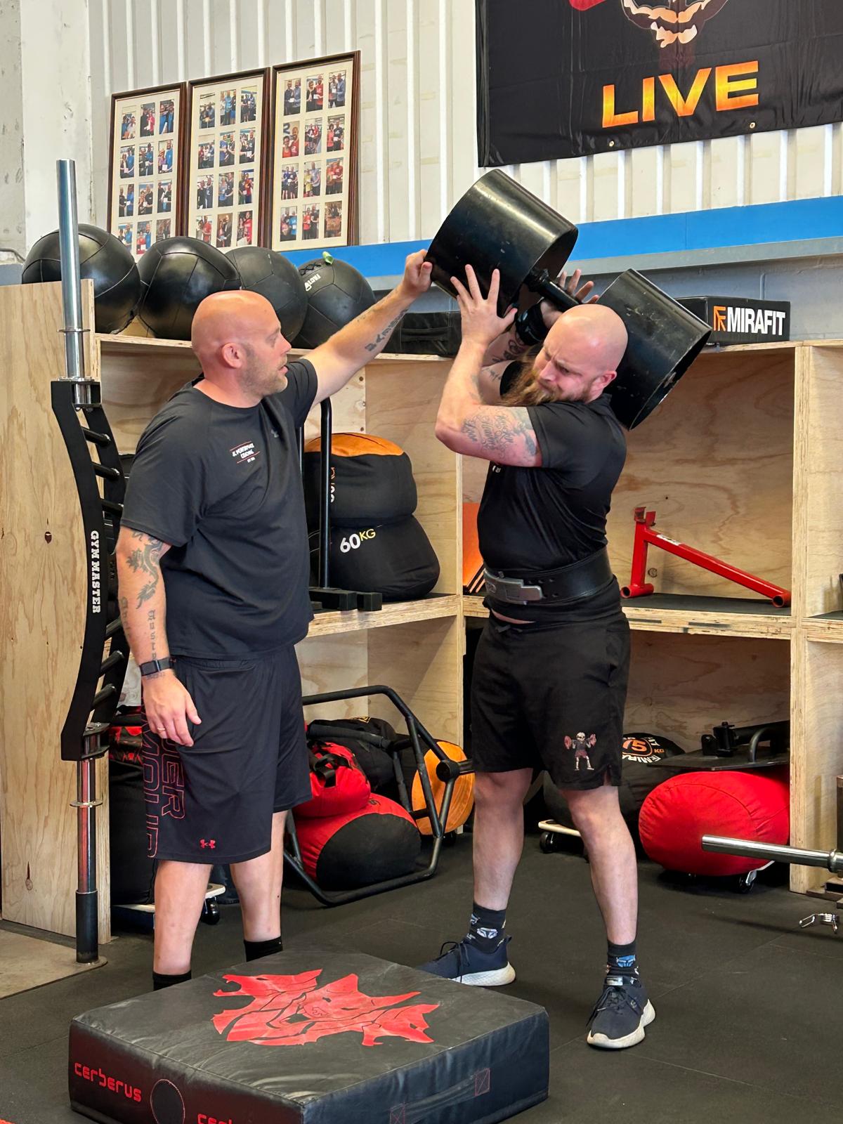 Coach working with a strength athlete during training