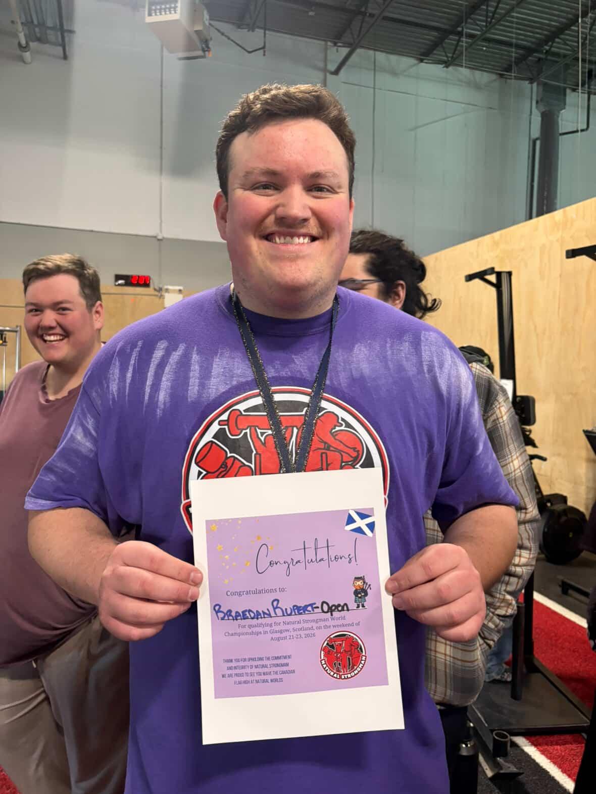 Smiling strength athlete holding a winning certificate