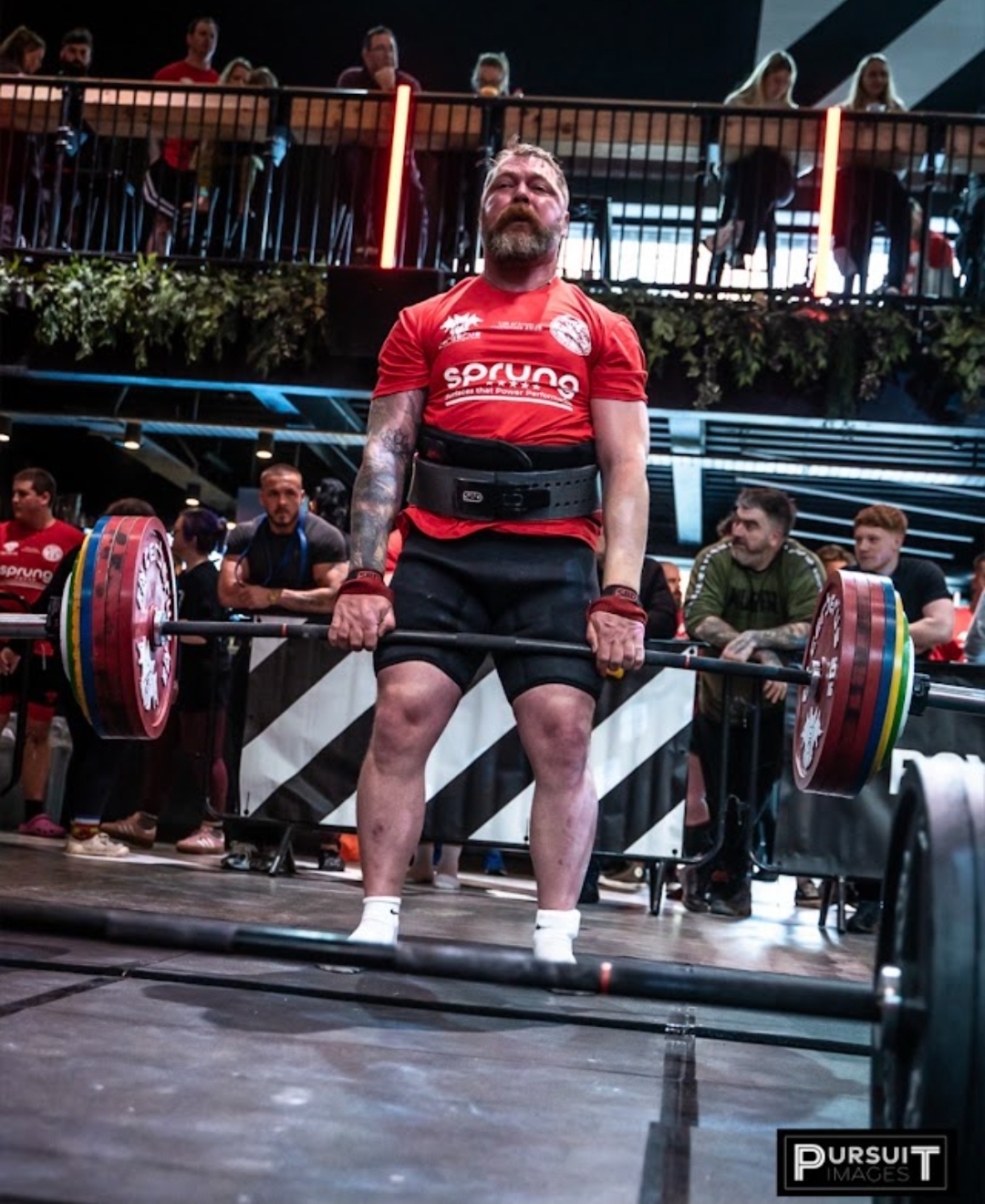 Strongman competitor lifting on stage during competition